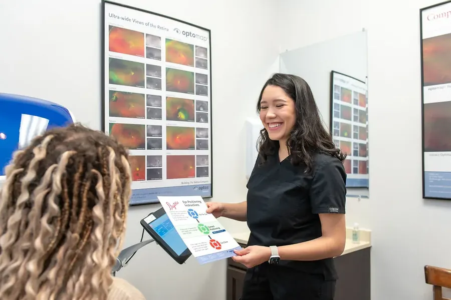 A TSO Kyle patient seated at the Optomap retinal imaging system during a comprehensive eye exam