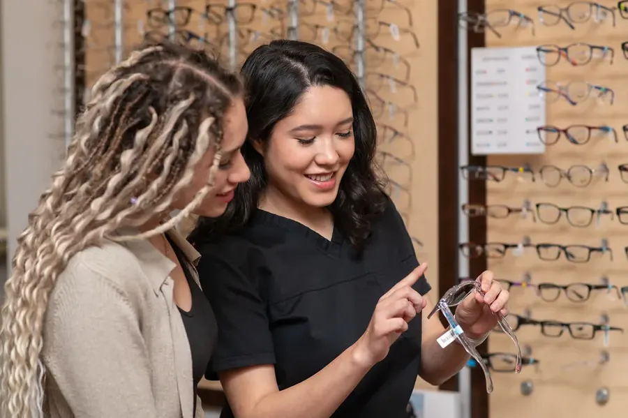 A TSO Kyle optician helping a patient choose frames at the frame wall