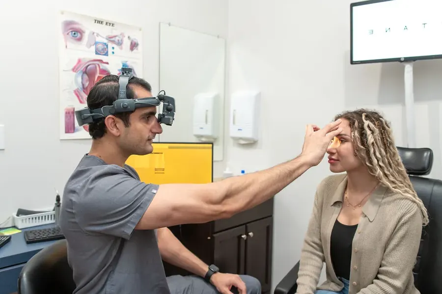 Dr. Waqar examining a patient with a binocular indirect ophthalmoscope