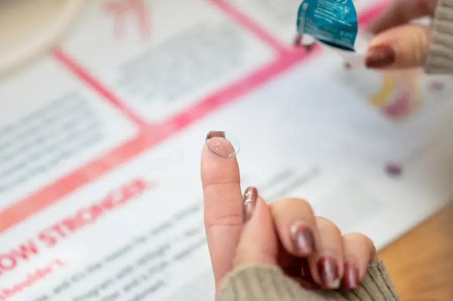 A MiSight daily myopia control contact lens resting on a fingertip